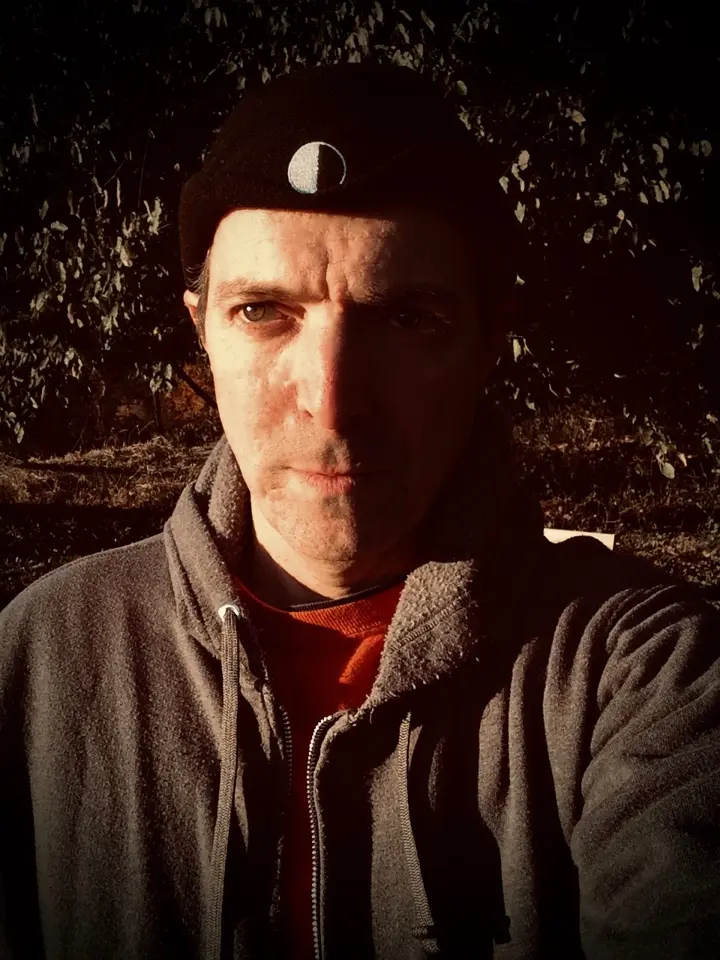 Moon Hat selfie in late-day sunlight: the half-lit first quarter Moon image on the hat matches the lighting on my face