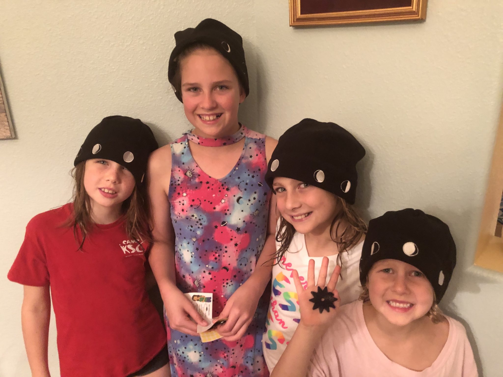 4 smiling girls ages 6-12 showing off Moon Hats and Sun Trackers