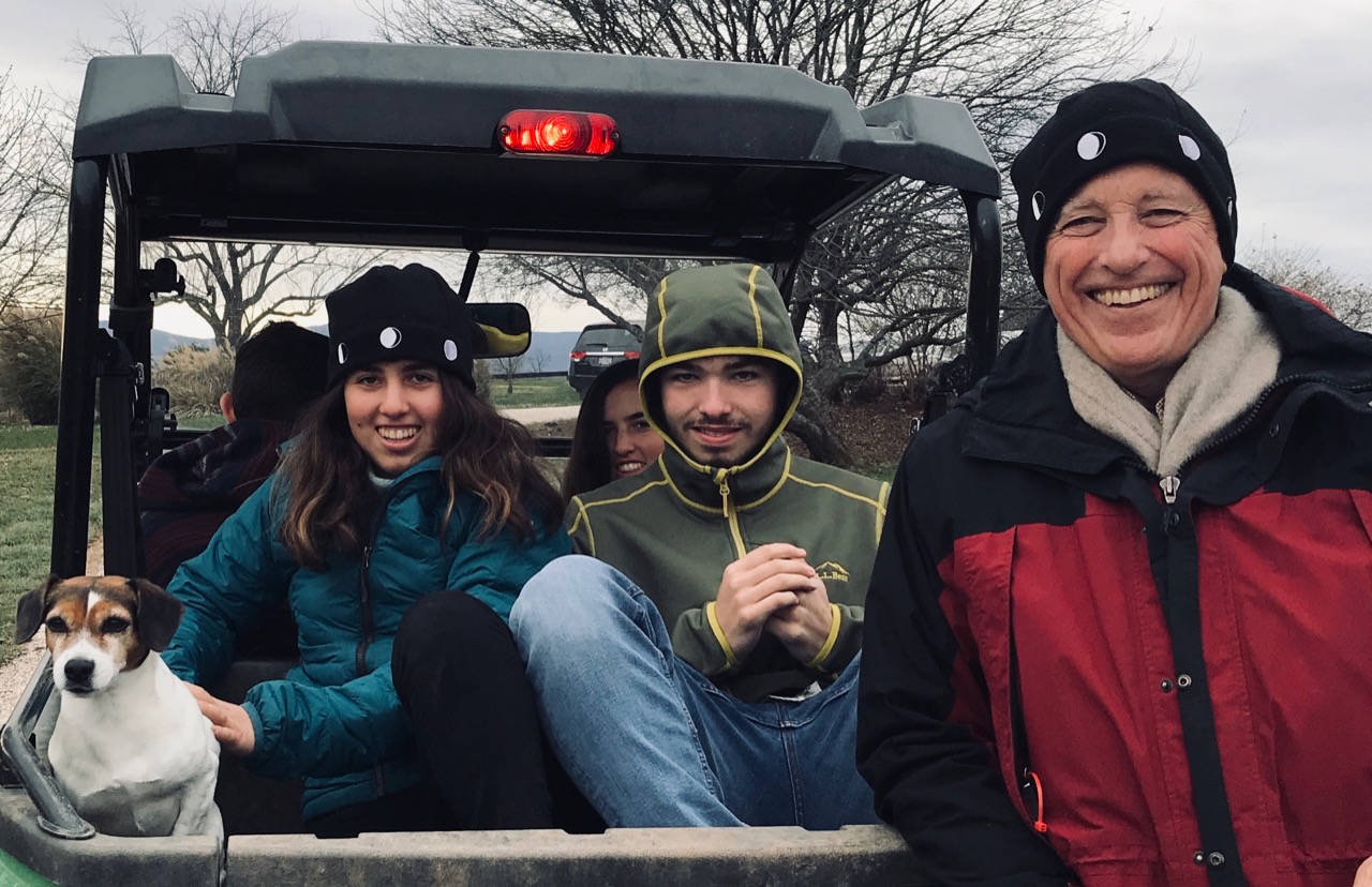 Family on people mover outside, two wearing the Moon Hat
