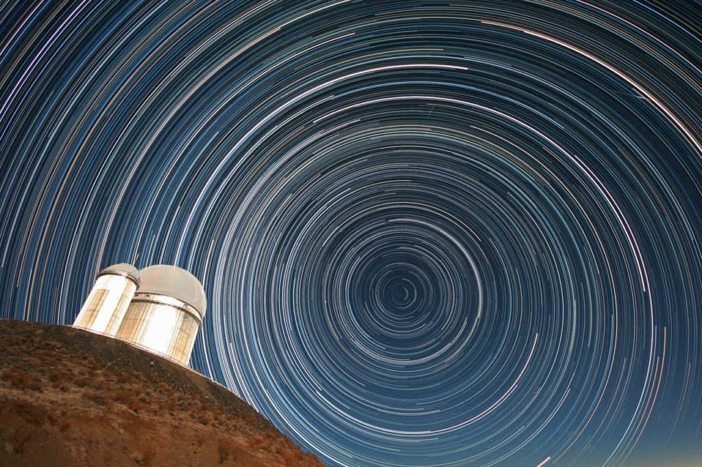 Can you find the North Star in this image? It is the star that is closest to the middle of the concentric rings of star trails. This is a long exposure photograph of real stars as seen over the course of several hours during the night.